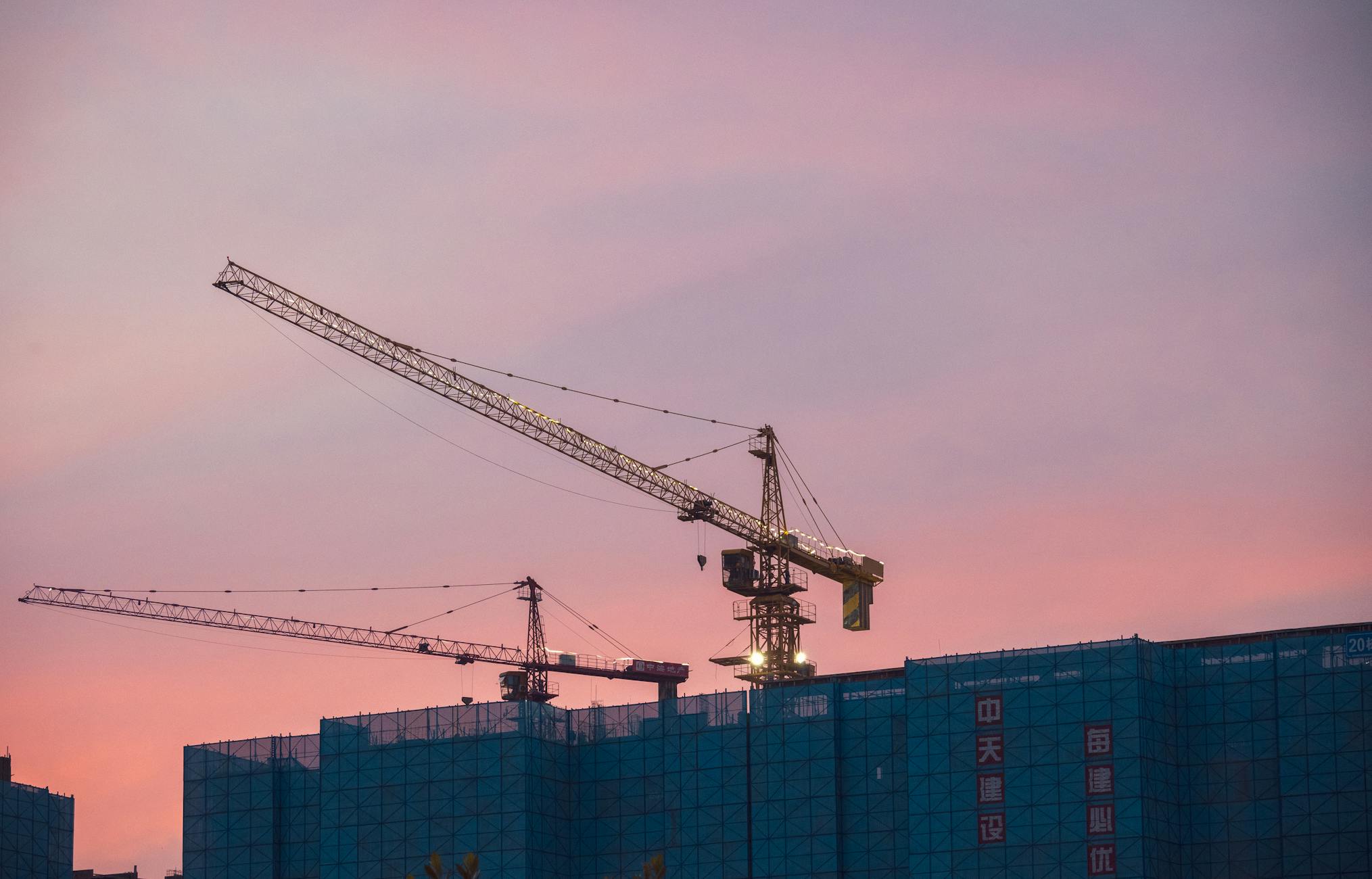 Construction crane over the skyline at sunset
